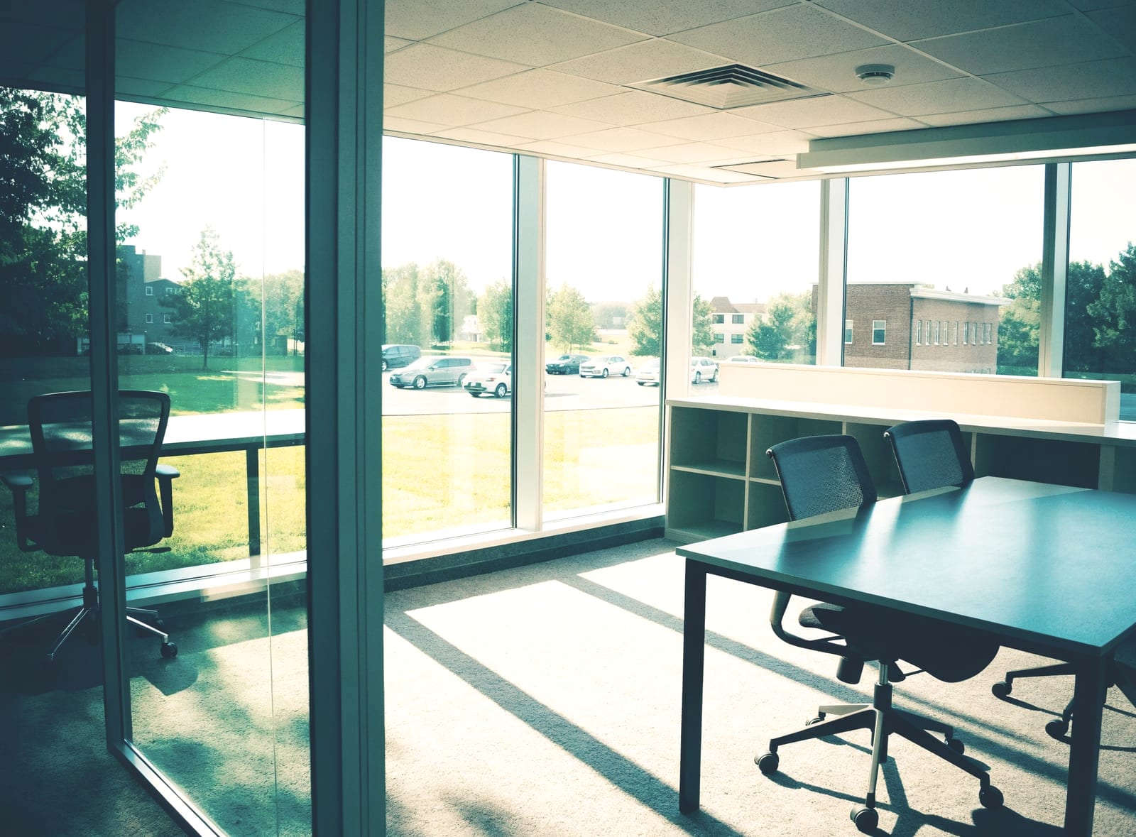 Empty modern office with desks and large windows