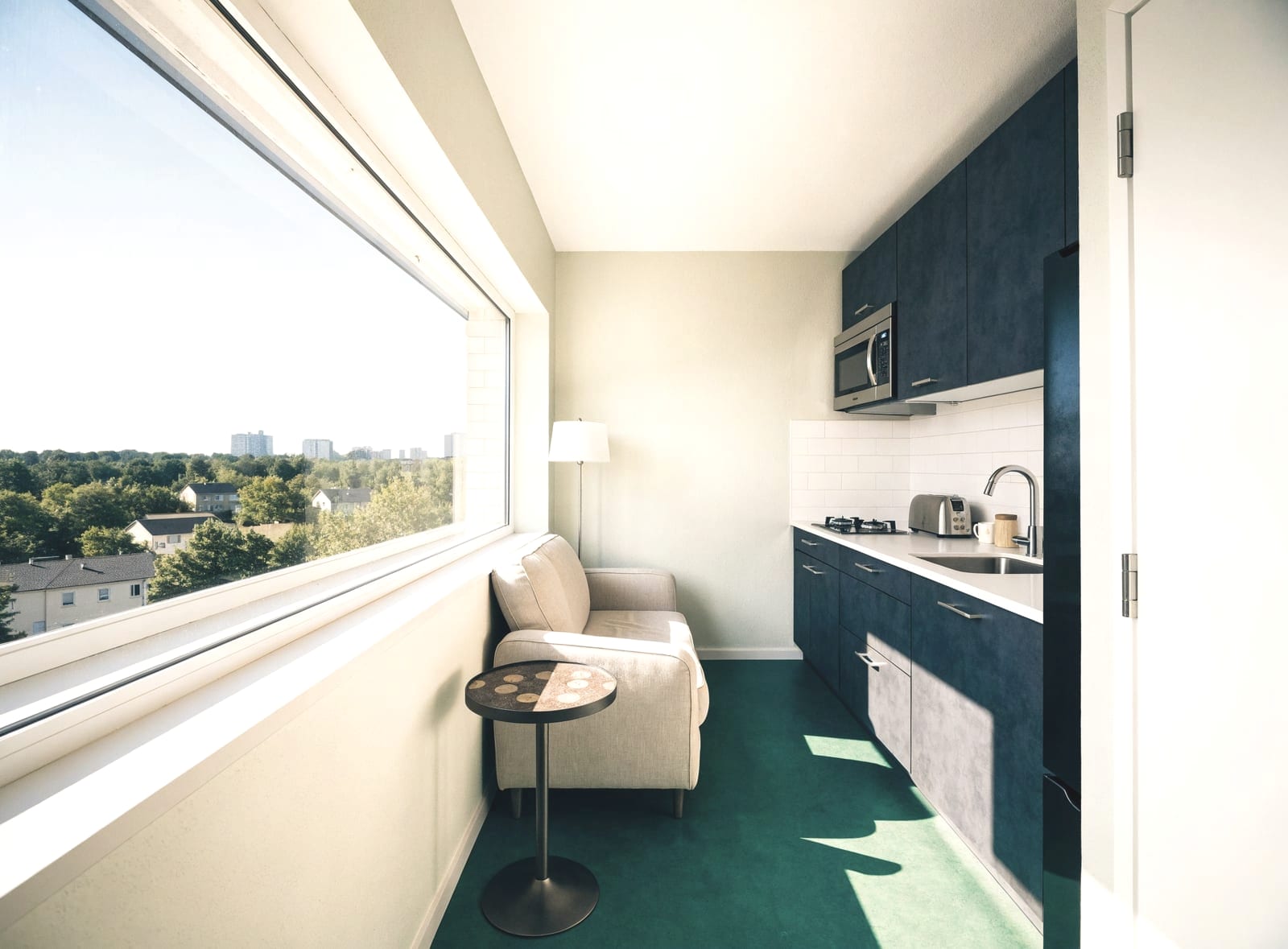 Small apartment kitchen and living area with a large window and a city view